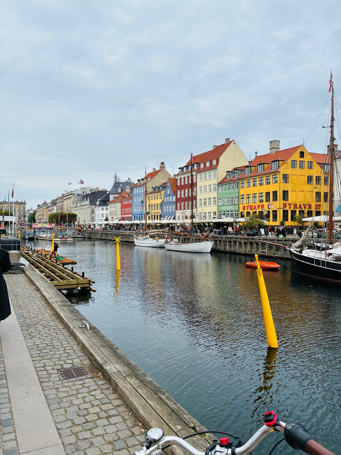 View of Nyhavn canal from a bicycle, with colourful buildings lining the waterfront